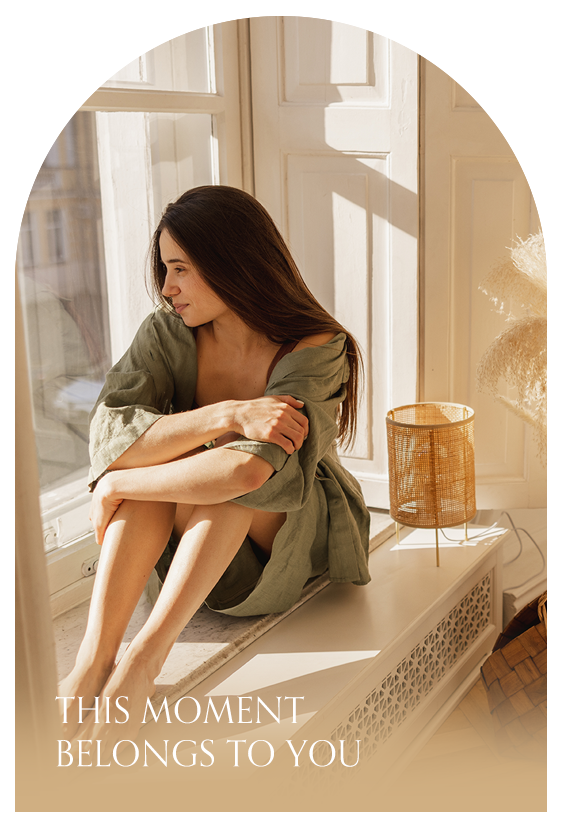 女性坐在窗邊看向窗外很悠閒的照片